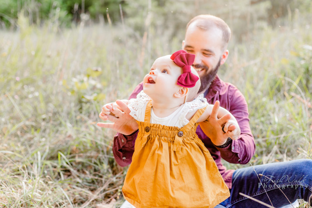 Shenandoah-Valley-family-session-portrait-father-daughter-happy-baby-golden-yellow-maroon-hair-bow-girl